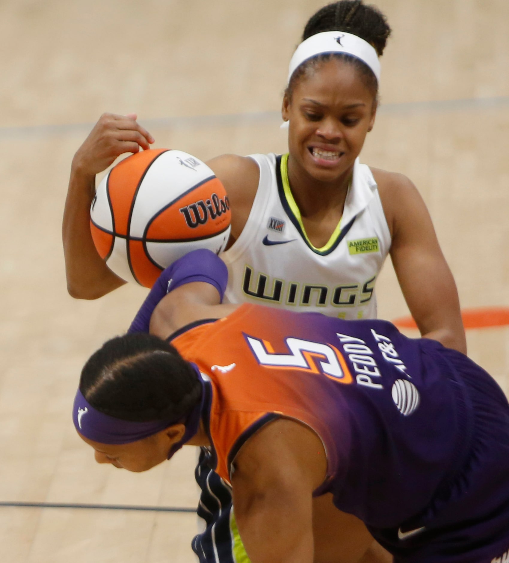 Dallas guard Moriah Jefferson (4), top, wrestles a loose ball scramble from Phoenix guard...