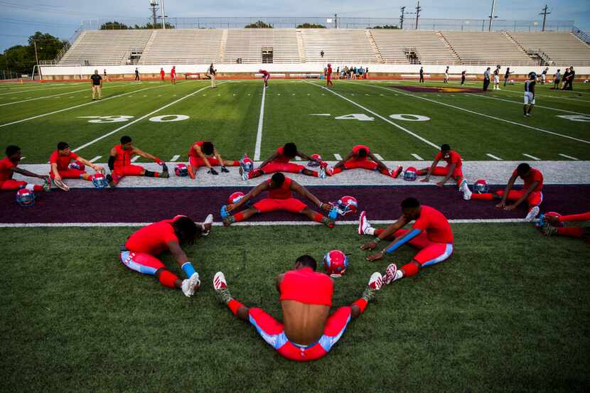 Carter football players stretch before a 4A high school football game between Carter and...