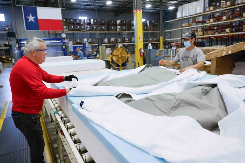 Milton Sleeping Company factory workers William Delgado (left), and Luciano Reyes work on...