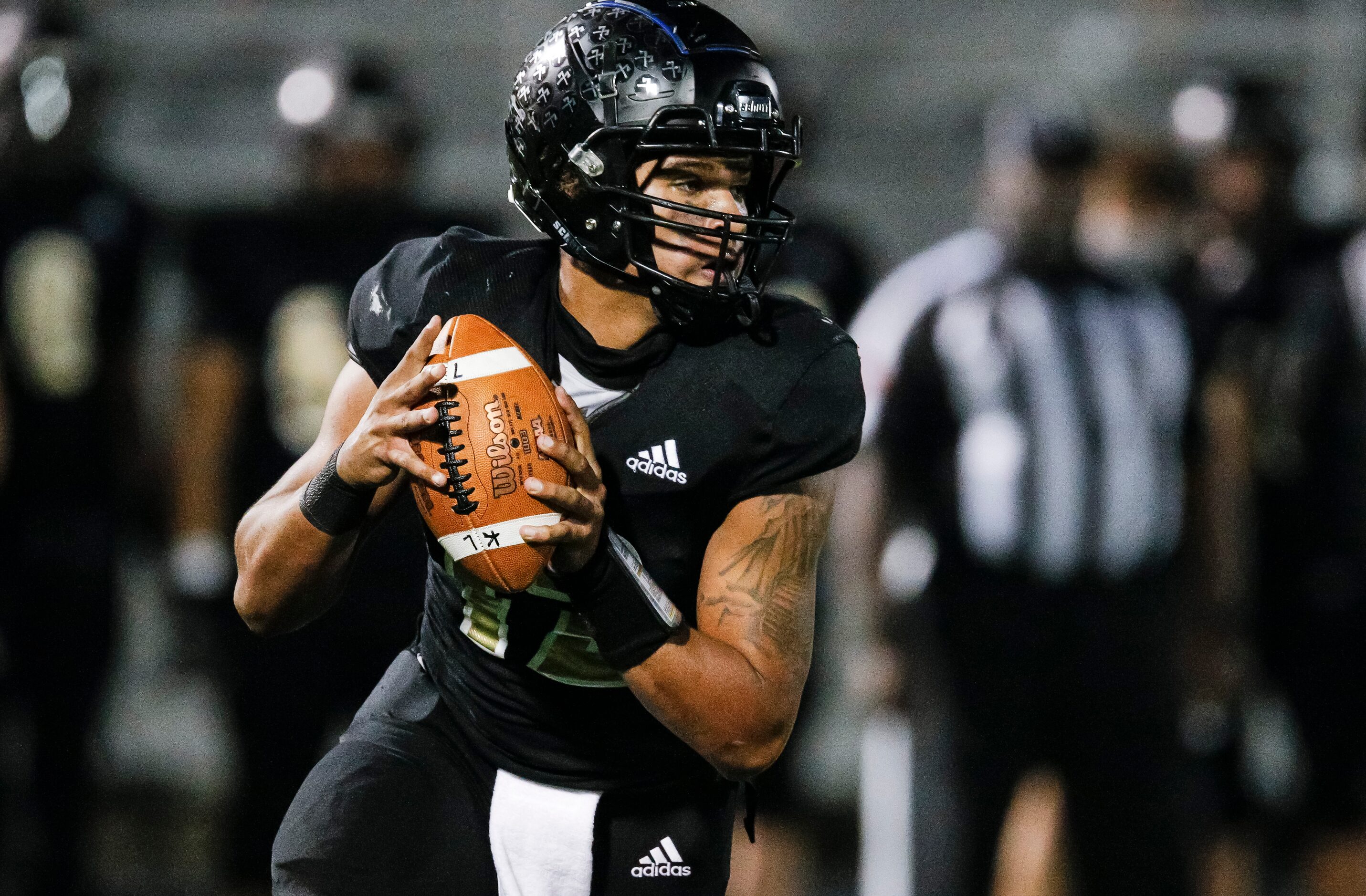 Kaufman senior varsity quarterback Ladamian Bailey (12) looks for an open receiver during...