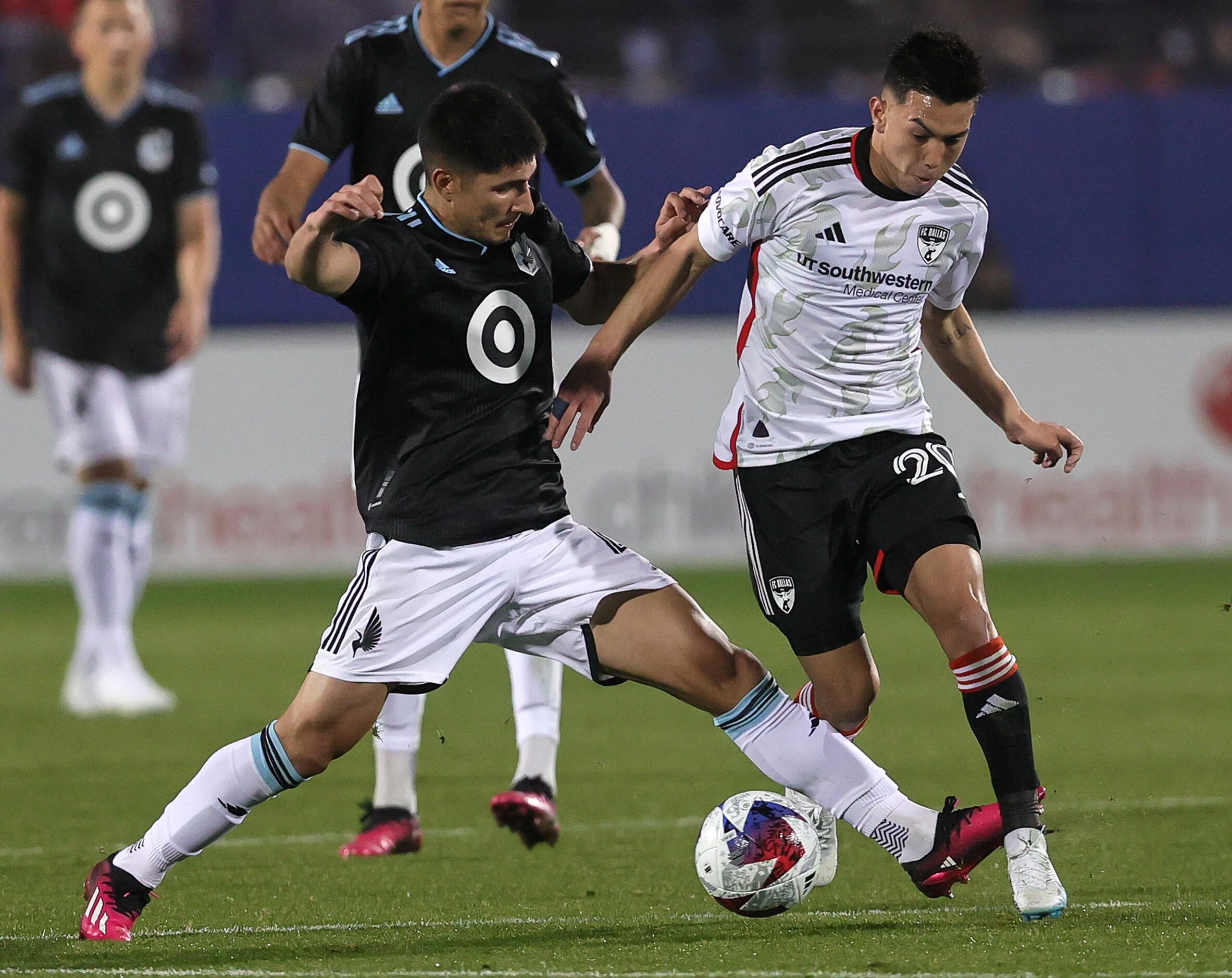 FC Dallas attacker Alan Velasco (20) tries to dribble the ball past Minnesota United...