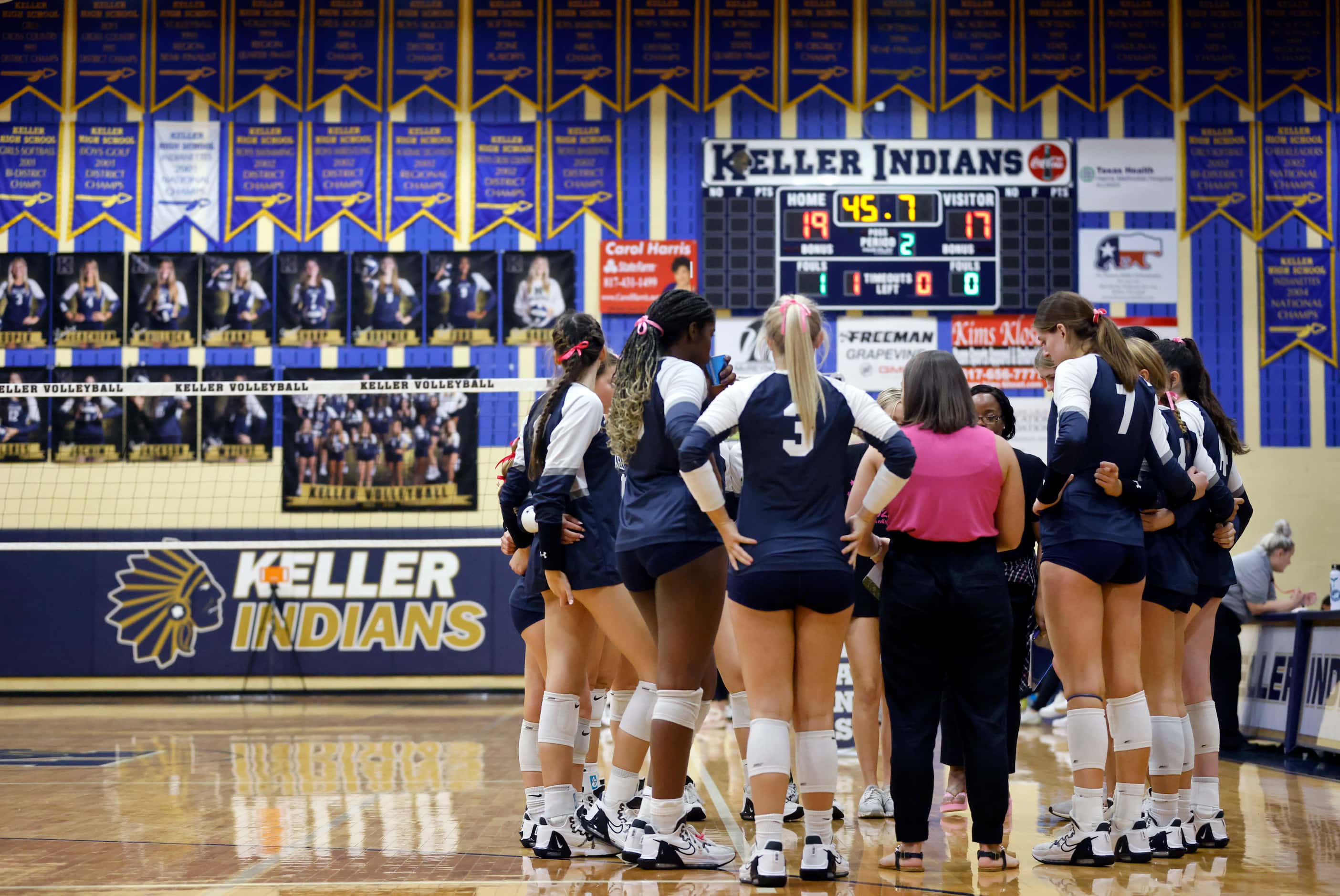 Players gather around Keller High head coach Danielle Barker (in pink) during a timeout...