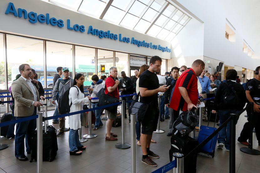 FILE - This April 22, 2013 file photo shows travelers standing in line at the LAX...