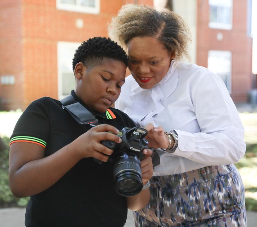 Isaac Edwards shows his mother, Stephanie Edwards, a portrait he took of her in one of the...