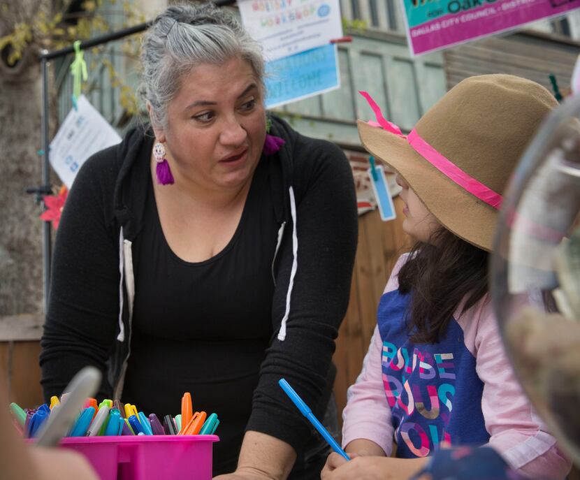 Ofelia Faz-Garza helps her daughter, Paloma Garza, 7, write a letter at the booth she was...