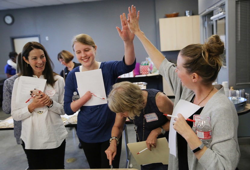 Susan O'Brien (left) of Hail Merry, watches as Charlsie Doan (second from left), a student...