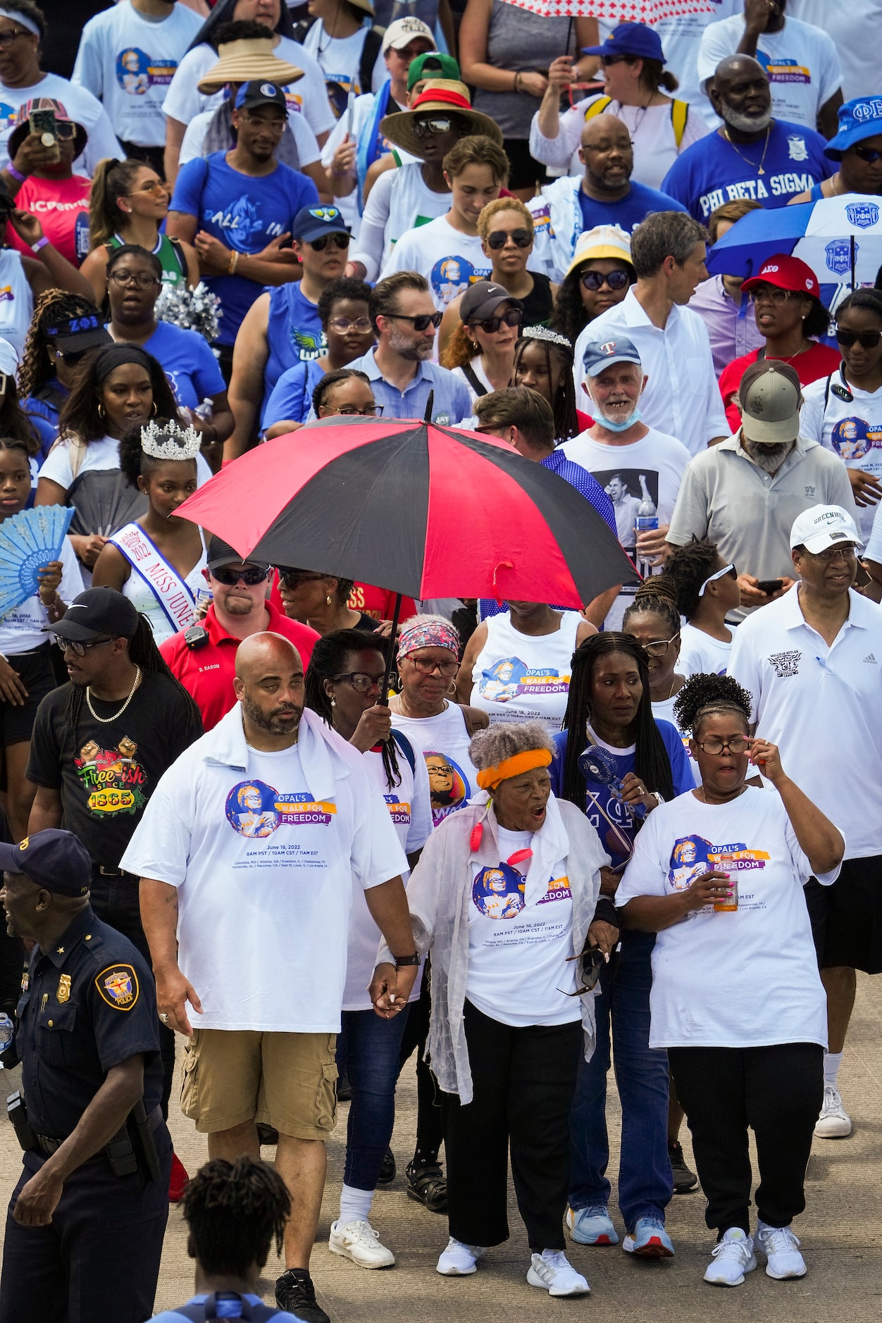 Opal Lee (center, bottom, wearing headband) leads hundreds of walkers along Hemphill Street...