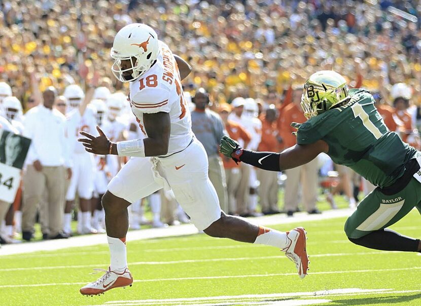 Texas quarterback Tyrone Swoopes (18) gets away from Baylor Taylor Young on the way to score...