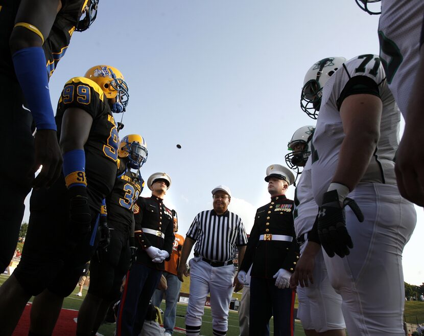 A pair of Marines make the official coin toss at mid field before Southlake Carroll (right)...