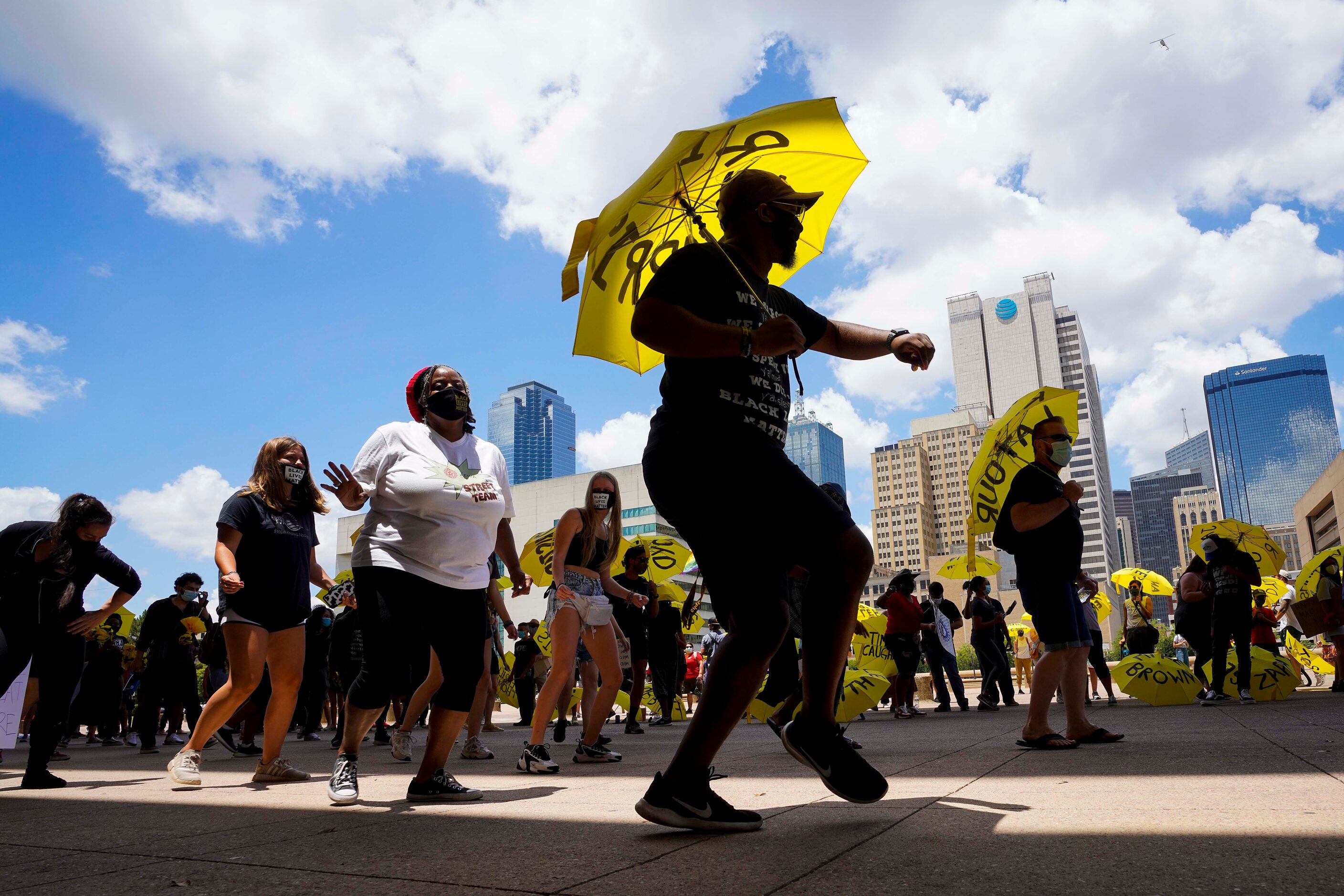 Relius Johnson dances while carrying an umbrella, one of 239 handed out bearing the names of...