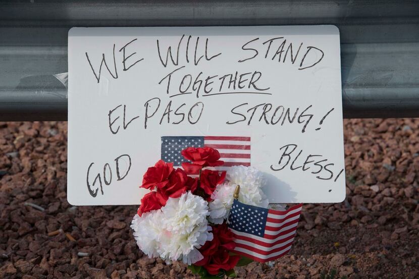 Flowers and signs are seen at a makeshift memorial after the shooting that left 21 people...
