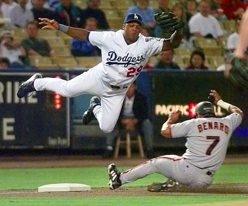 FILE - San Francisco Giants' Marvin Benard slides safely under a leaping Los Angeles...