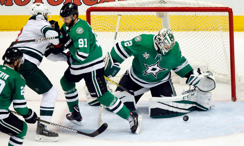 Dallas Stars goaltender Kari Lehtonen (32) reaches for a shot on goal by Minnesota Wild...