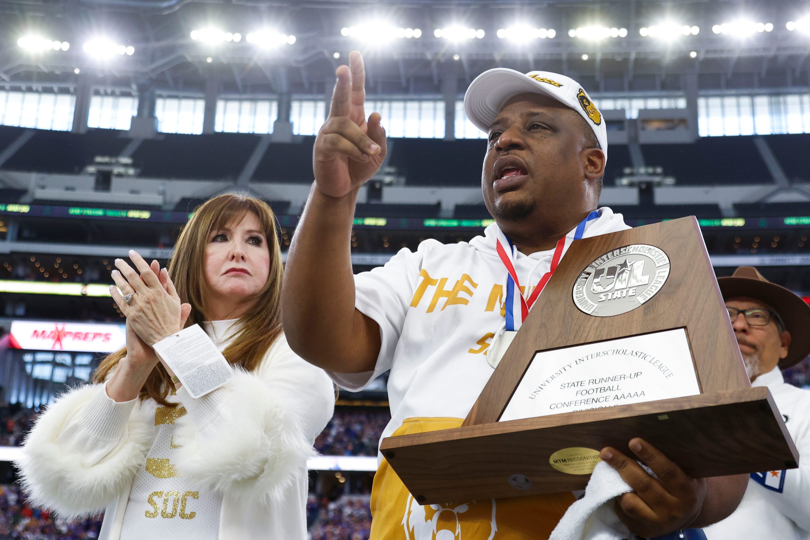 DISD Superintendent Dr. Stephanie S. Elizalde (left) applauds South Oak Cliff head coach...