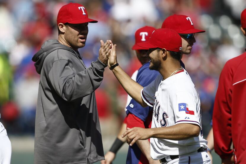 Texas Rangers' Colby Lewis congratulates pitcher Martin Perez (right) for his win against...