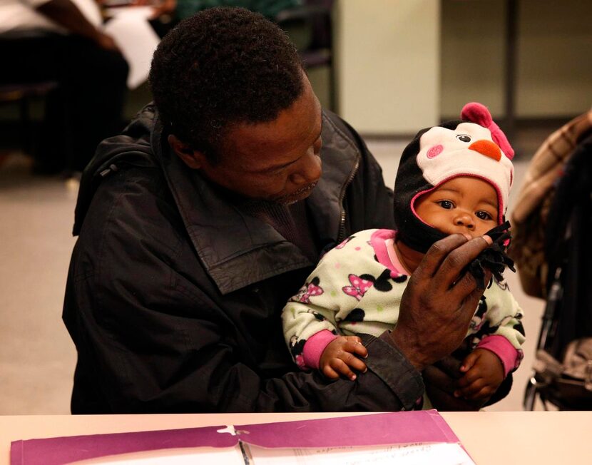 
Anthony Smith held his 10-month-old daughter, Antoinette, while waiting for legal aid at...