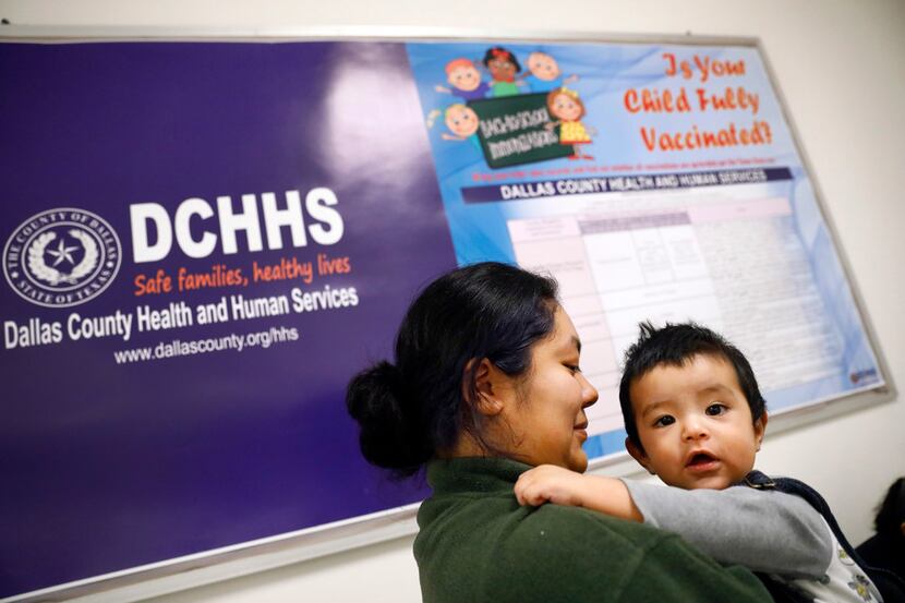 Vanessa Esquivel of Mesquite waits for an influenza shot for her 8-month-old son, Juan, at...