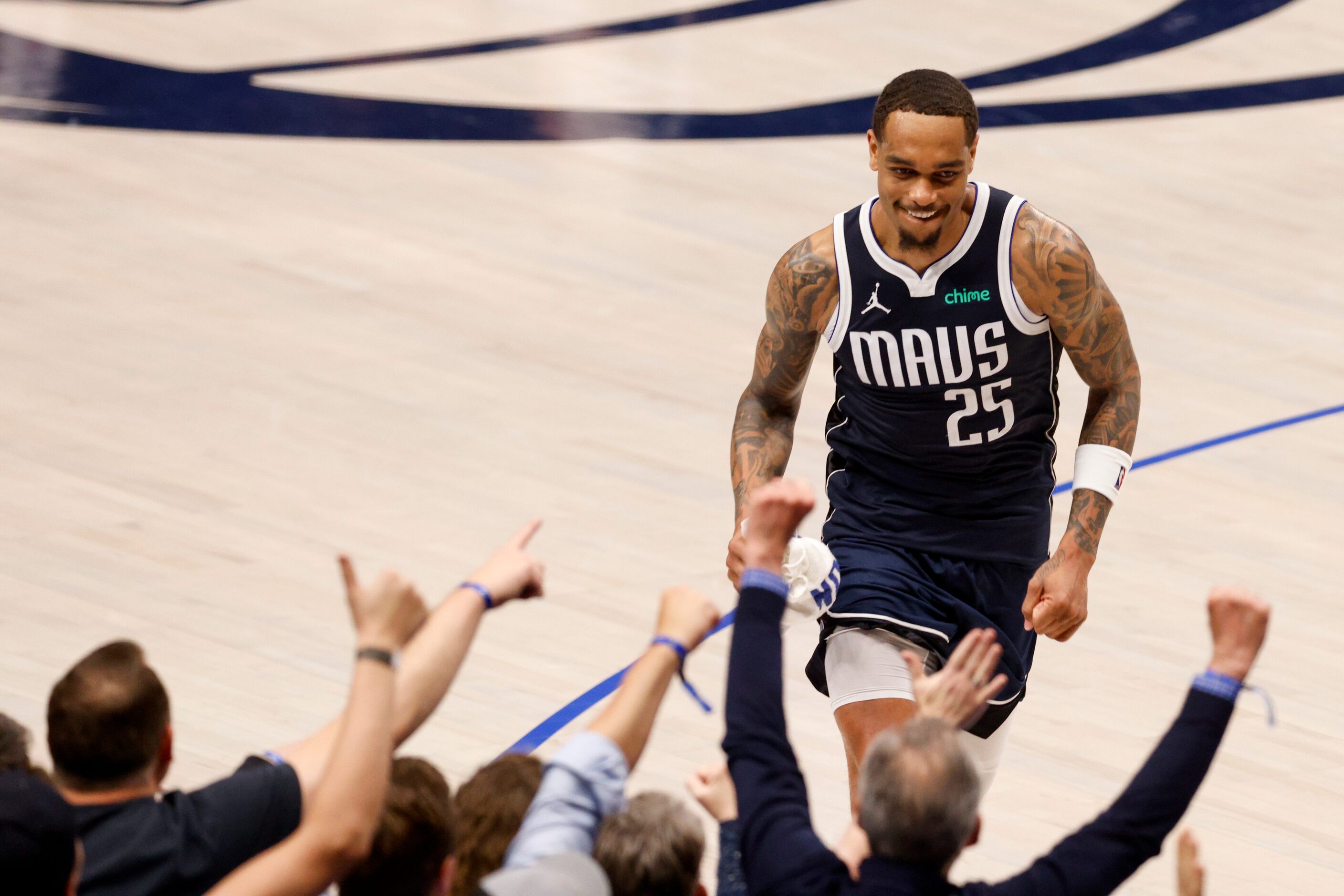 Dallas Mavericks forward P.J. Washington (25) smiles as he high fives fans after being...