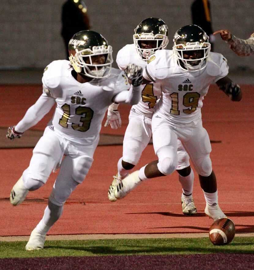 South Oak Cliff Rapheal Williams (19) races from the field with teammates Donjaz Dunn (13)...
