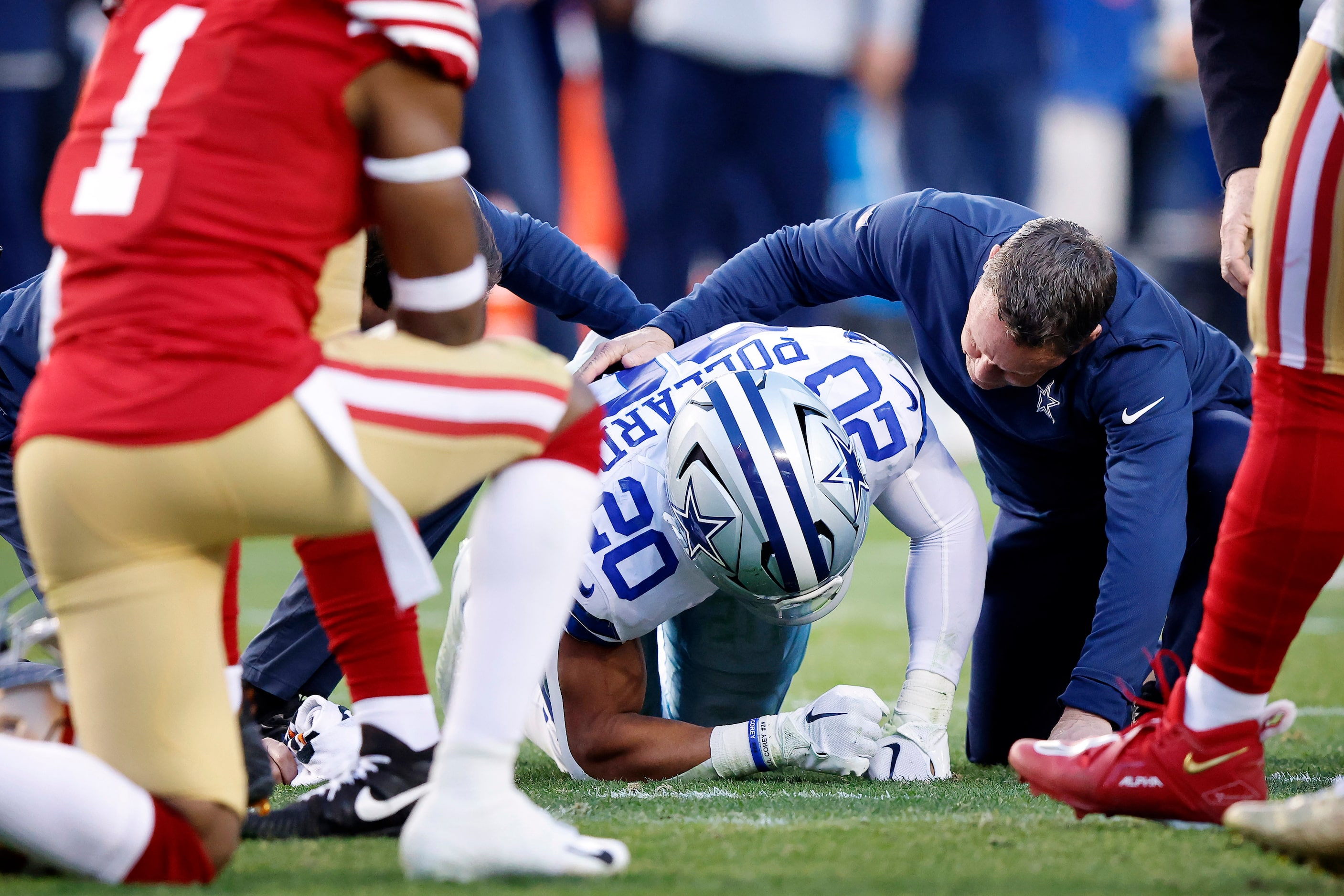 Dallas Cowboys running back Tony Pollard (20) is attended to after sustaining a first half...