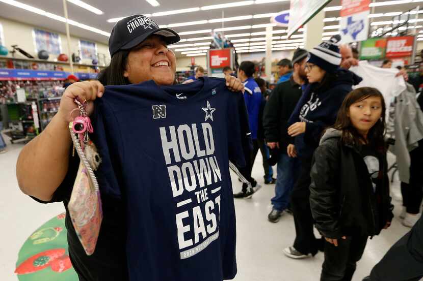 Cowboys fan Carmen Grant poses for a photograph with a Cowboys NFC East Champion t-shirt at...