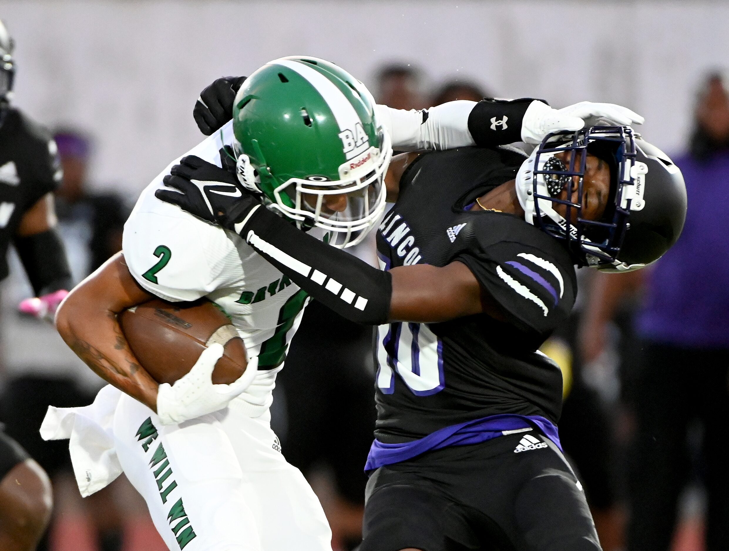 Bryan Adam’s Jordan Smith (2) stiff arms Lincoln’s Jaylen Mitchell (10) in the first half...