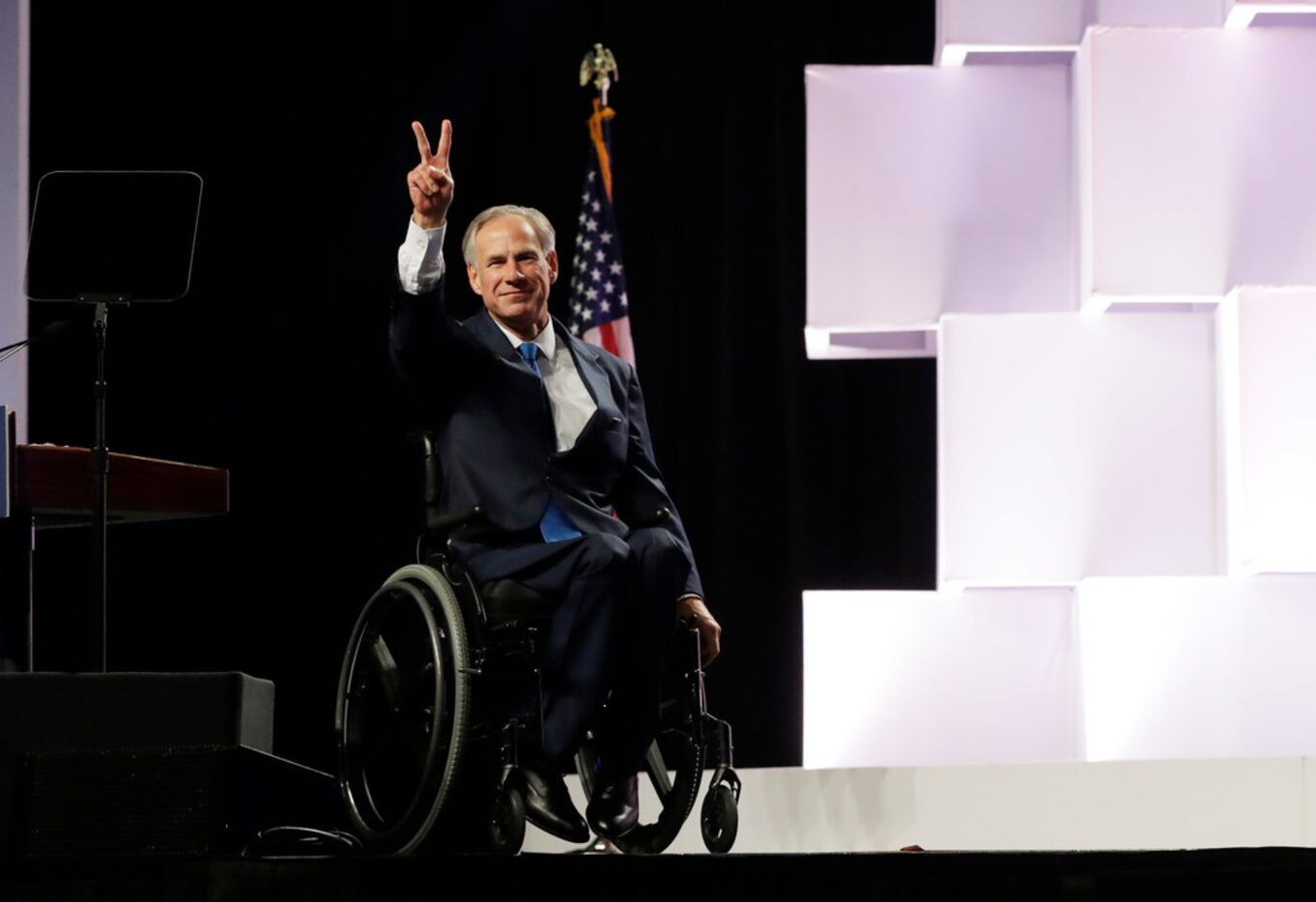 Texas Gov. Greg Abbott waves to delegates at the Texas GOP Convention in San Antonio.