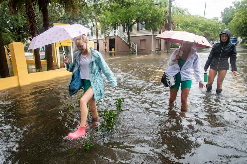 Pedestrians make their way down Montagu St. in Charleston, S.C., as Tropical Storm Debby...