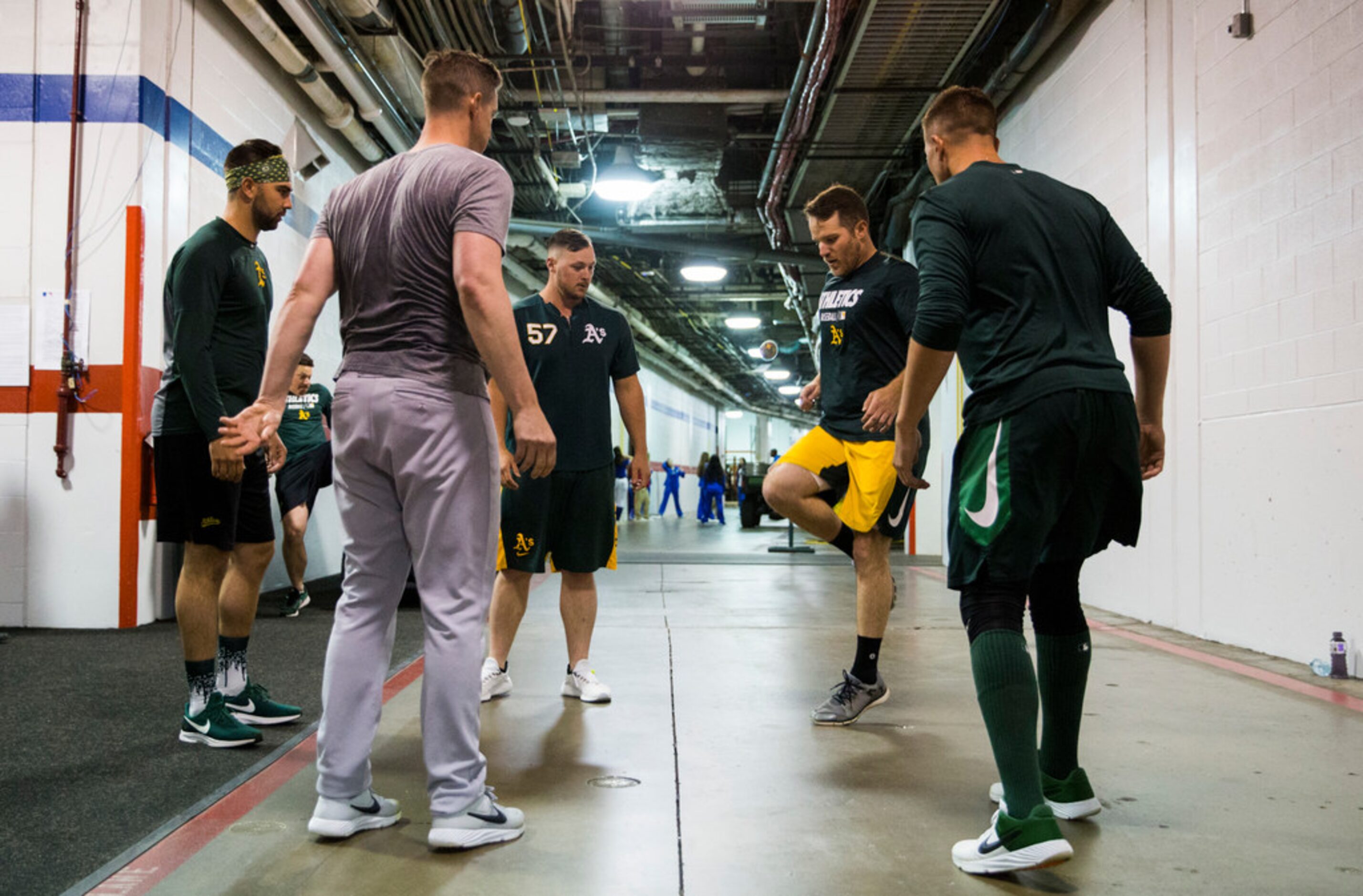 Oakland Athletics players play hacky sack in the tunnel during a rain delay at an MLB game...