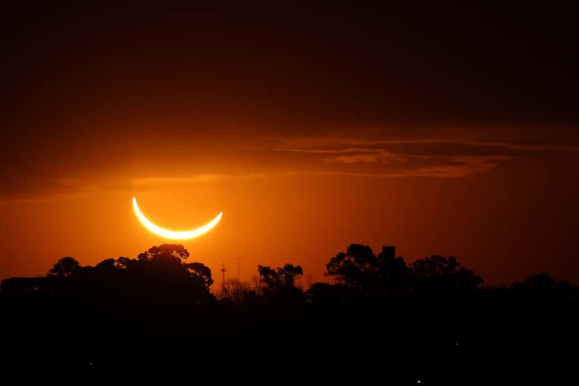 FILE - The moon passes in front of the setting sun during a total solar eclipse in Buenos...