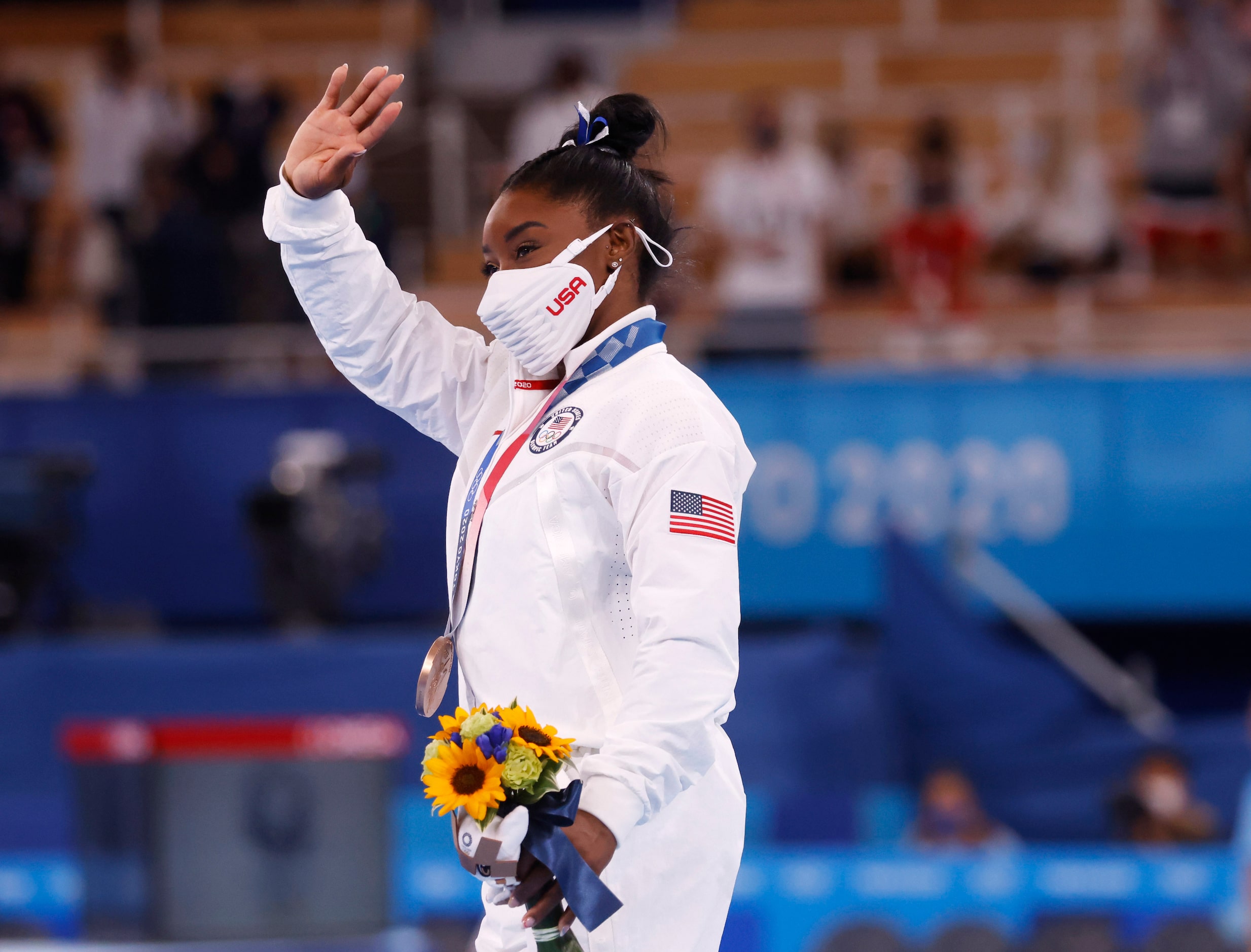 USA’s Simone Biles walks around the stage with her bronze medal during the medal ceremony...