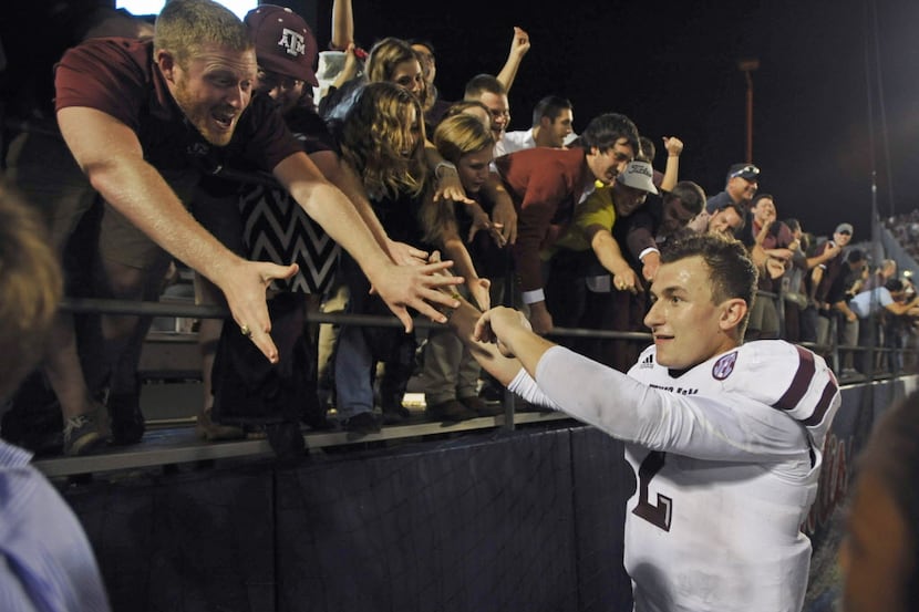 Texas AM quarterback Johnny Manziel celebrates with fans following an NCAA college football...