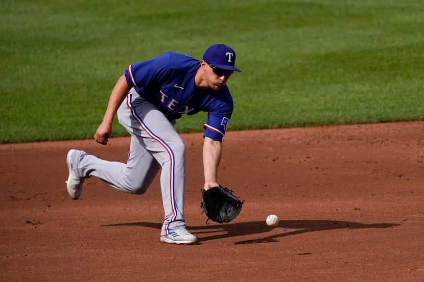 Texas Rangers shortstop Corey Seager fields a slow roller before firing to second baseman...