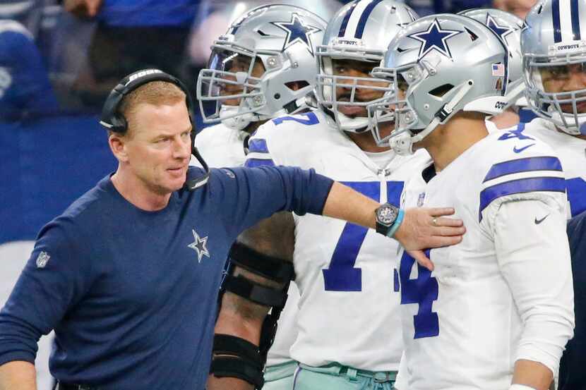 Dallas Cowboys head coach Jason Garrett offers an encouraging pat to quarterback Dak...
