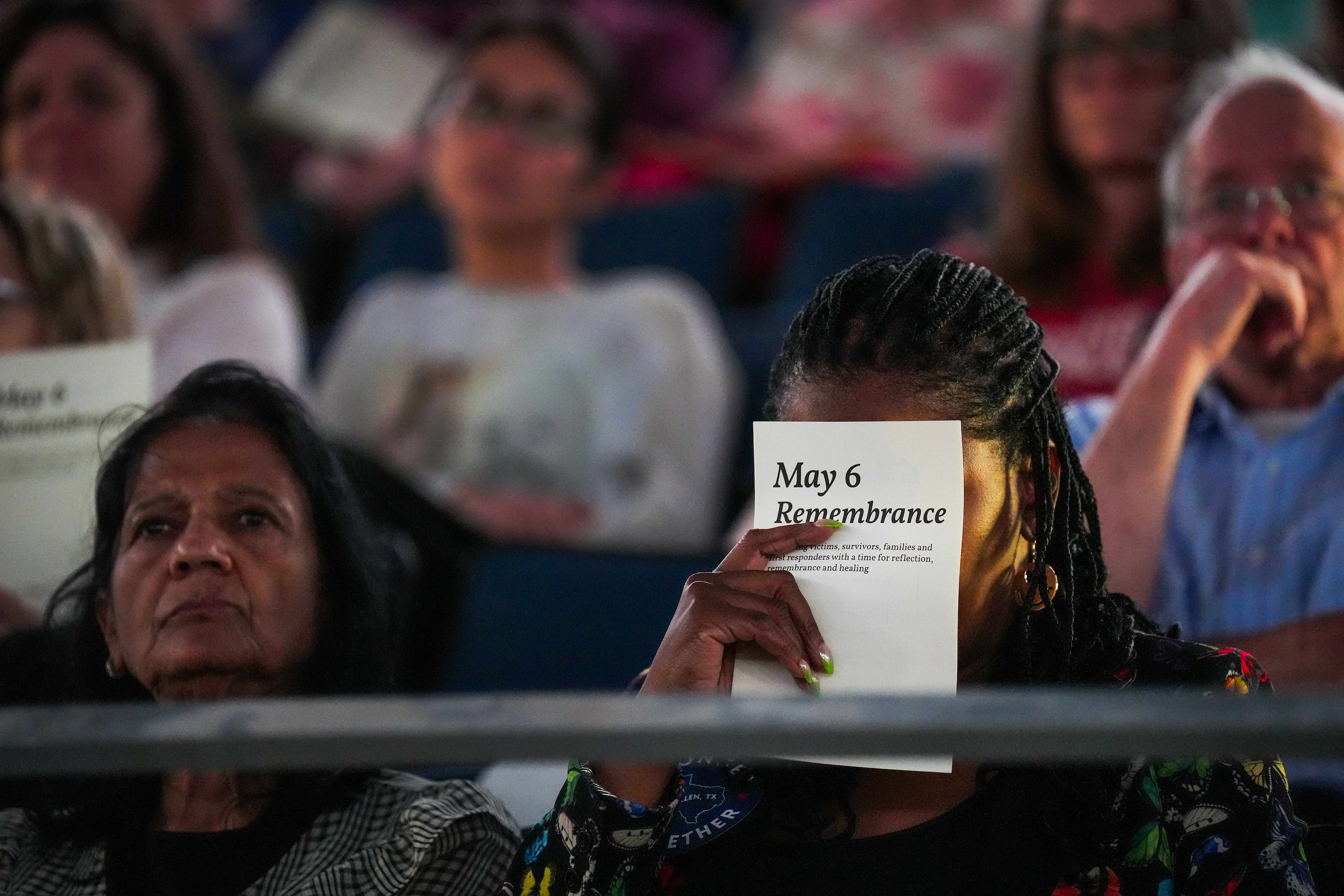 Cheryl Jackson covers her face with a program as she tears up while listening to the Allen...