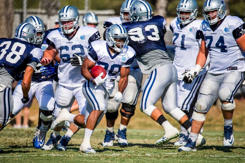 Dallas Cowboys running back Lache Seastrunk (30) breaks through the defense during afternoon...