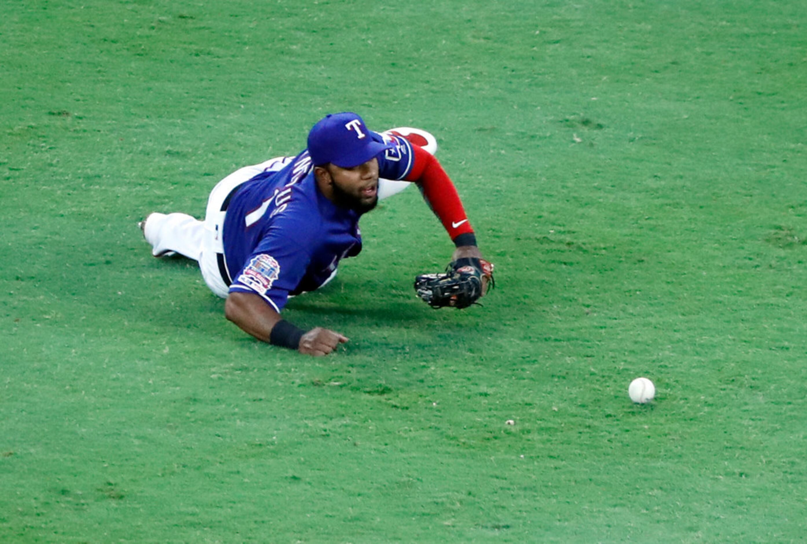 Texas Rangers shortstop Elvis Andrus dives to reach a single by Oakland Athletics' Khris...