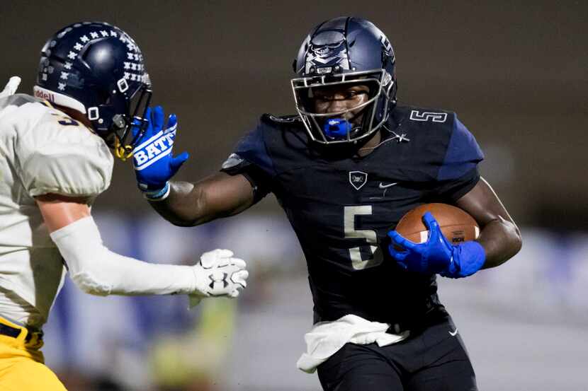 Wylie East Raiders Eno Benjamin (5) carries the ball with a stiff arm during a varsity...
