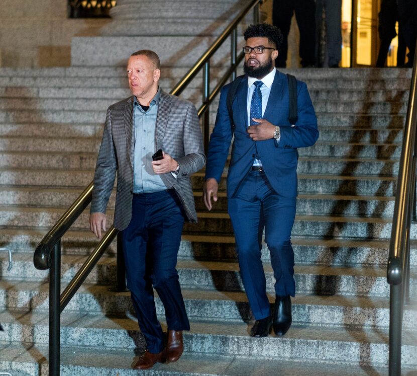 Dallas Cowboys star Ezekiel Elliott, right, exits federal court after a hearing Monday in...