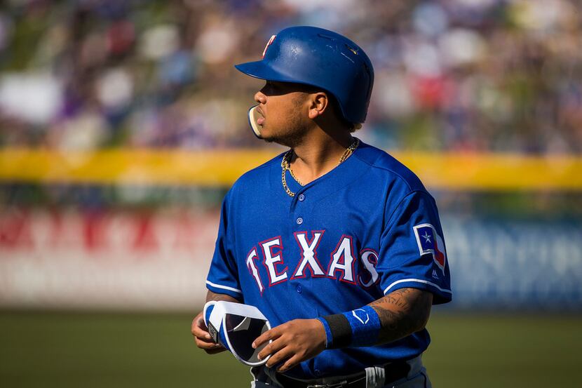 Texas Rangers outfielder Willie Calhoun heads back to the dugout after hitting into a double...