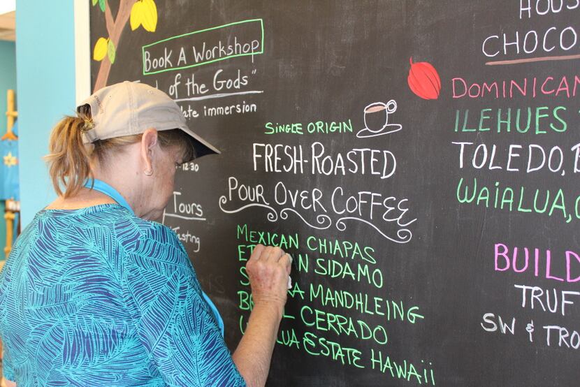 Melanie Boudar updates the chalkboard at the entrance to Cacao chocolatier in Santa Fe, NM. 