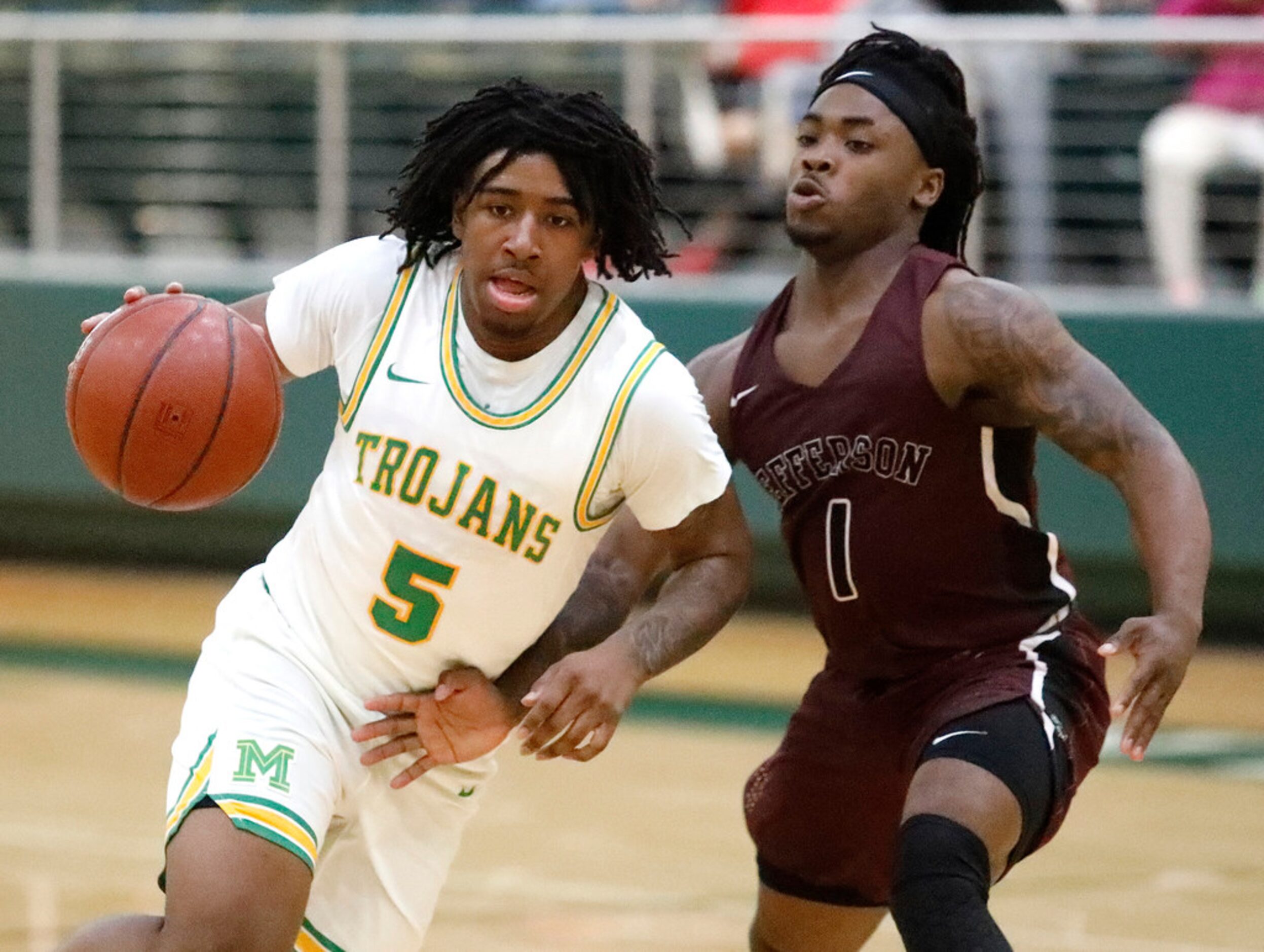 Madison High School guard Dye'Shun King (5) is defended by Jefferson High School guard Dee...