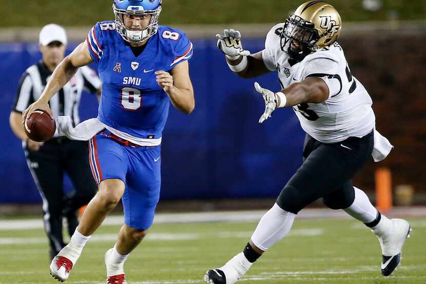 SMU quarterback Ben Hicks (8) is chased by UCF defensive lineman Tony Guerad (93) during the...