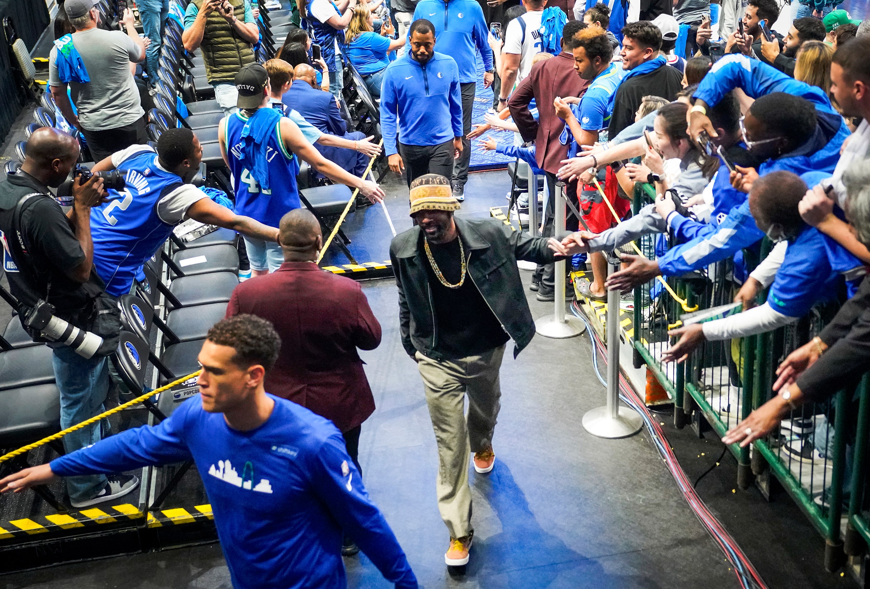 Dallas Mavericks guard Kyrie Irving (wearing knit cap) and center Dwight Powell (left) leave...