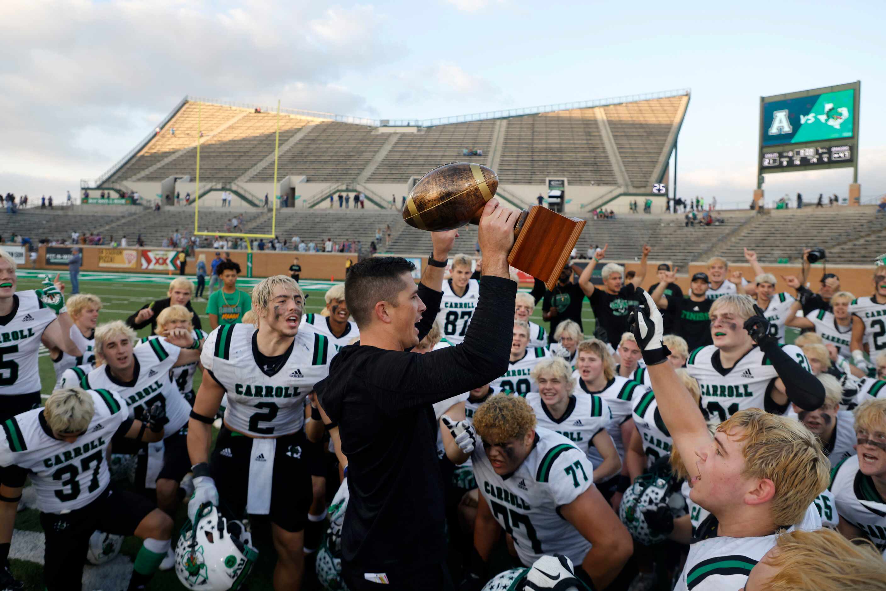 Southlake head coach Riley Dodge holds up the Region I trophy after they defeated Allen...
