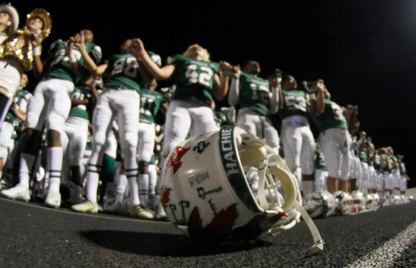 A football helmet lays on the track as members of the Waxahachie Indians celebrate their...