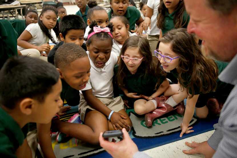 Second graders reacted as Geoff Gray of Primal Gardens shows them a photo of a large fish he...