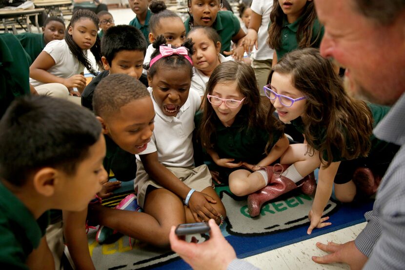 Second graders reacted as Geoff Gray of Primal Gardens shows them a photo of a large fish he...