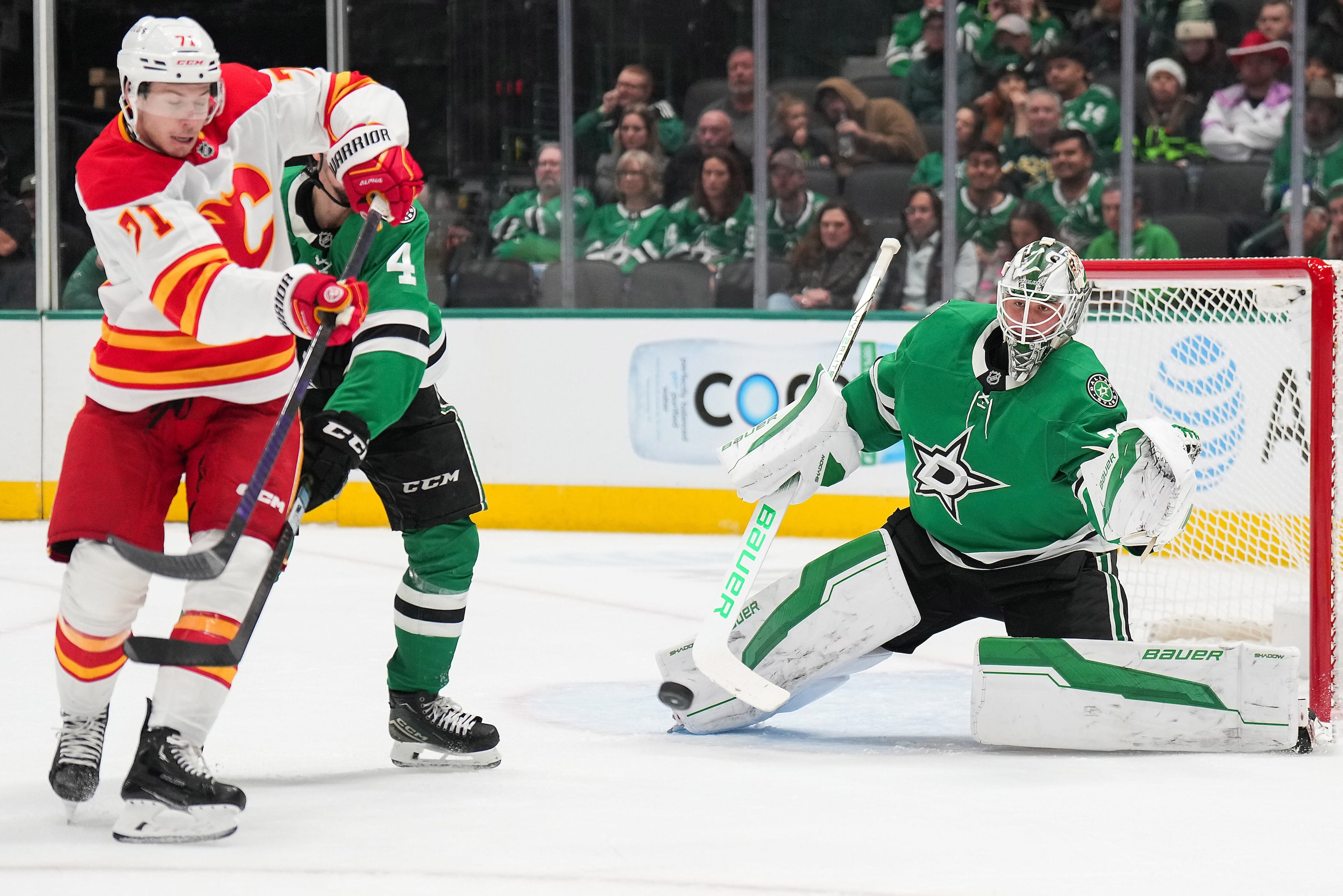 Dallas Stars goaltender Jake Oettinger (29) makes a save as Calgary Flames right wing Walker...