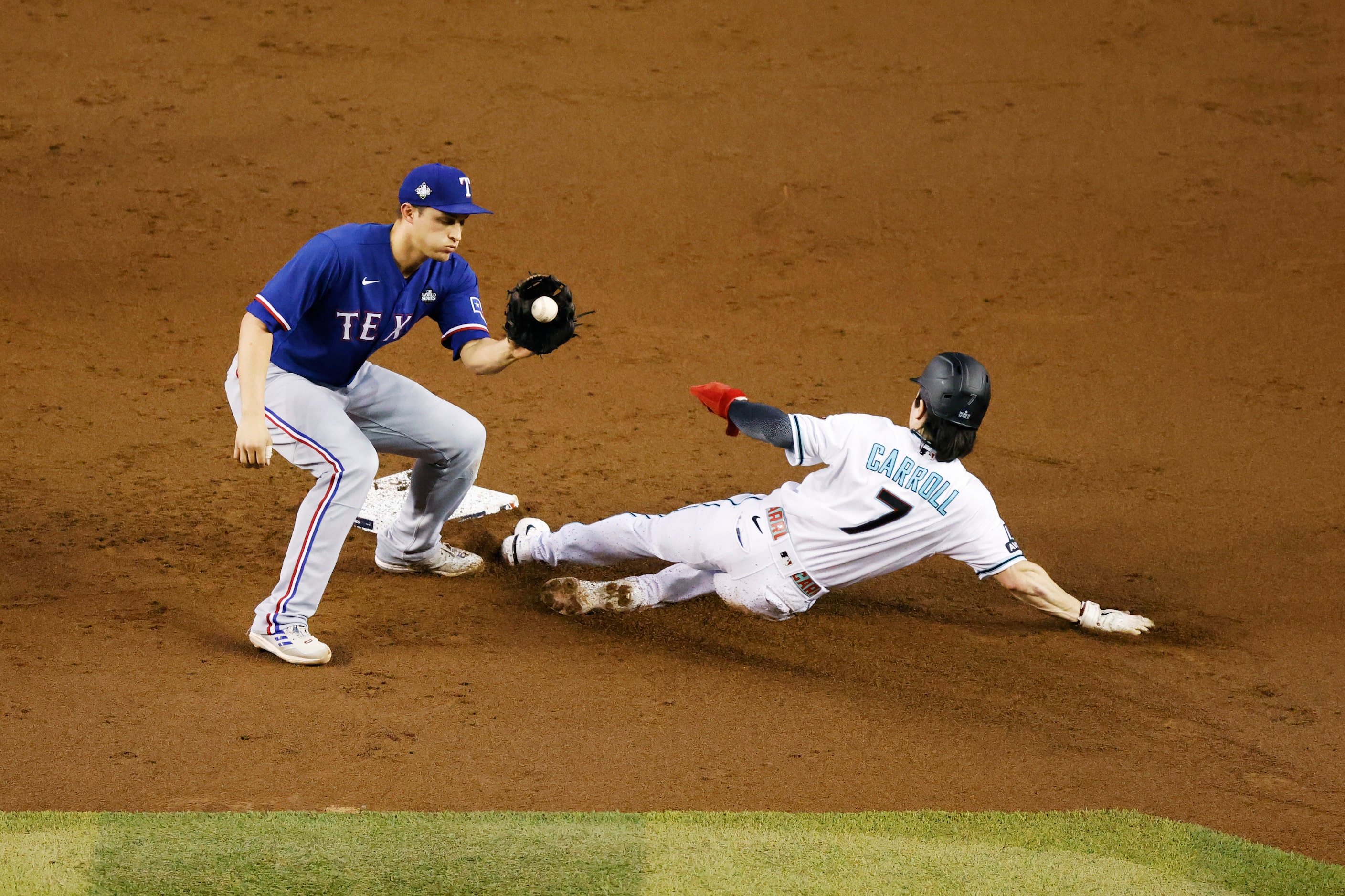 Arizona Diamondbacks’ Corbin Carroll steals second ahead of the tag from Texas Rangers...